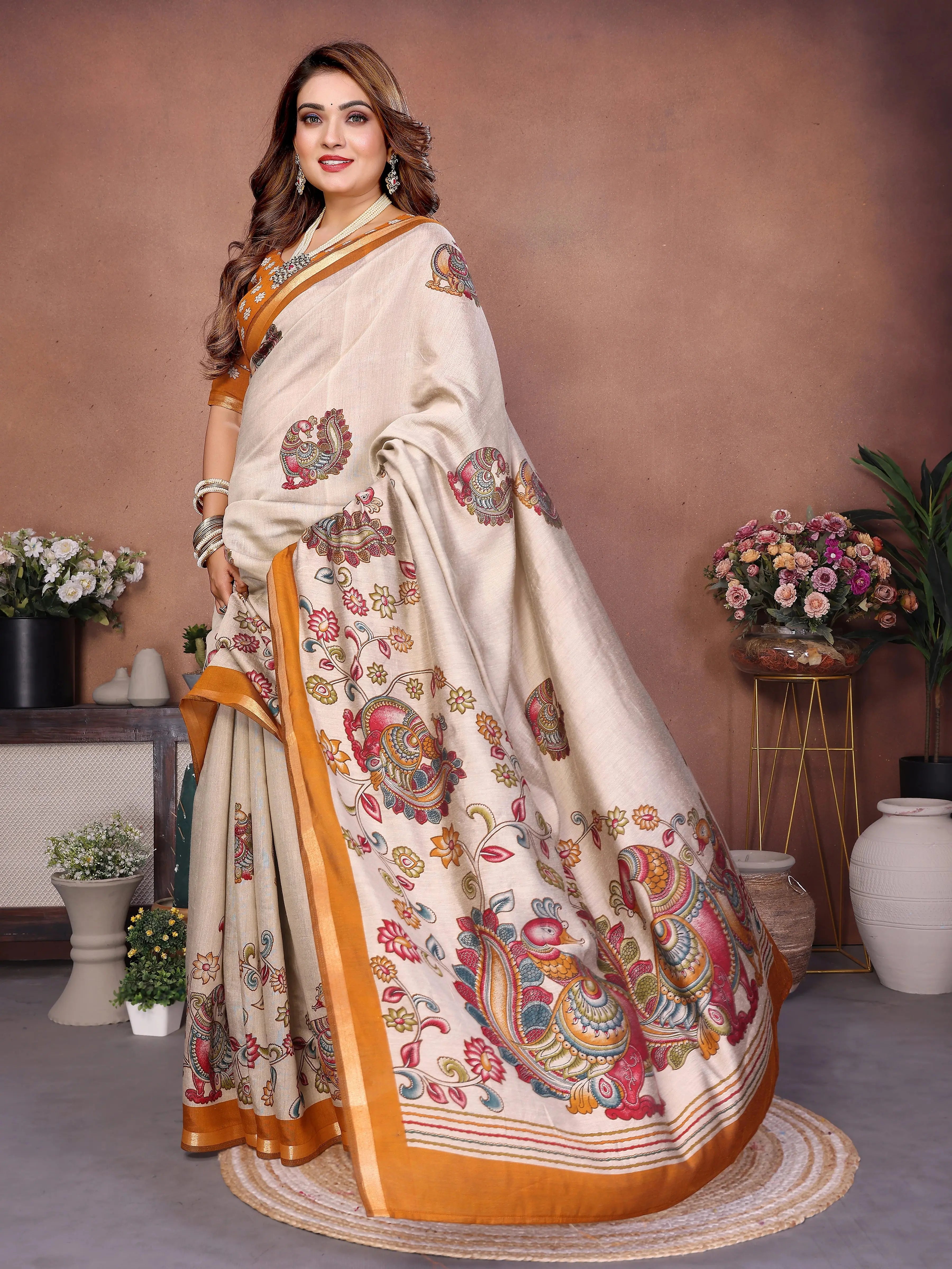Woman wearing a traditional saree with intricate patterns in a decorated indoor setting